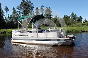 A big pontoon boat anchored in the river