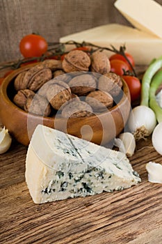 Big portion of niva cheese in front of various vegetable