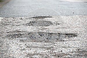 Big potholes on a road caused by ground frost