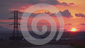 Big power station with huge electric pylons and incredible sunset