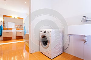 Big practical bathroom with washing machine photo