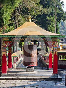 Big Prayer wheel at the entrance of the Enchey Monastry with a scenic backdrop of himalaya.