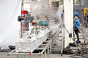 Big professional camera on rails. Outdoors movie set. Cinema production scene at city street. Candid real filmmakin