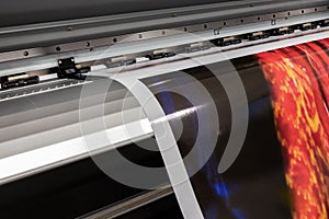 Big professional printer, processing massive vinyl red rolls.