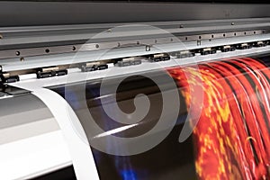 Big professional printer, processing massive vinyl red rolls.