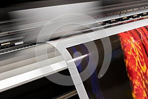 Big professional printer, processing massive vinyl red rolls.