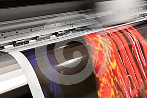 Big professional printer, processing massive vinyl red rolls.