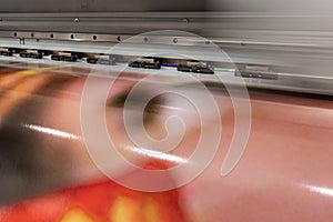 Big professional printer, processing massive vinyl red rolls.