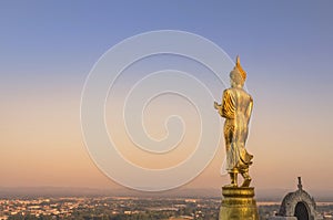 Big public big golden buddha statue standing in Wat Phra That Kao Noi at Nan province Thailand in sunset