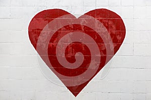 A big red heart is painted on a white wall. graffiti, street art expressing love