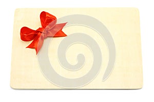 Big red holiday bow on a wooden board