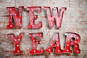 Big red letters with lamps - New Year - on brick photo