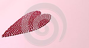 Big red love heart. Crystal circles mosaic shape heart concept on pink background. Flat lay side view, copy space valentines day.