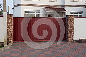 big red metal gate and fence on a rural street