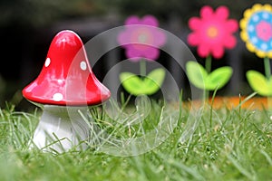 Big red mushroom toy with colorful artificial flowers in background