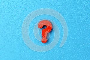 Big red question mark on a blue background. Copy the space, top view. Water drops