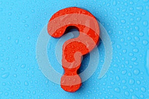 Big red question mark on a blue background. Copy the space, top view. Water drops