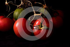 Big red and ripe tomatoes in an old basket on black background