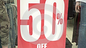 Big red sales sign in a shop window. 50 percent sales. Promotion. Consumerism concept.