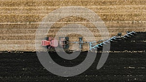 Big red tractor on on rubber tracks, Pulling productive reverse plow on Field. Preparation soil for Planting new crops