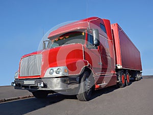 A big red truck stands on the asphalt.