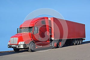 A big red truck stands on the asphalt.