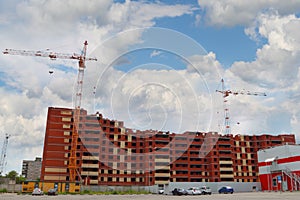 Big residential building under construction and two cranes