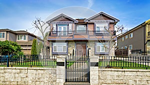 Big residential house with metal fence and gate on winter day