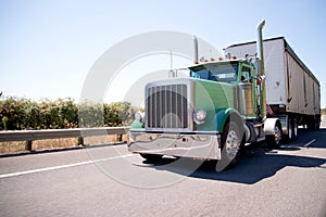 Big rig attractive green semi truck with bulk trailer