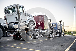 Big rig powerful semi truck transports new semi trucks tractors coupled one on top of another to form a road train photo