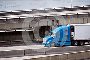 Big rig blue pro semi truck transporting reefer semi trailer on photo