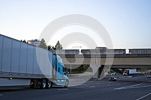 Big rig blue semi truck with dry van semi trailer transporting c