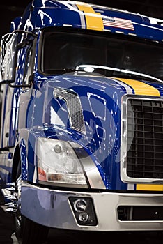 Big rig blue semi truck with yellow strip on cabin