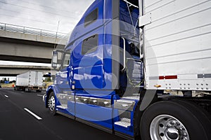 Big rig bright blue long haul semi truck transporting goods in r