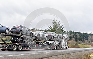 Big rig car hauler semi truck transporting cars on special two level modular semi trailer