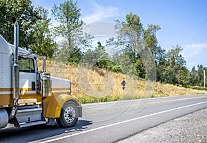 Big rig classic semi truck tractor with vertical chrome pipes running on the winding road in Columbia Gorge