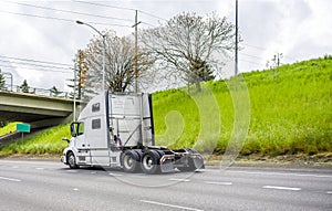 Big rig diesel semi truck tractor running on the highway road to warehouse for pick up loaded semi trailer