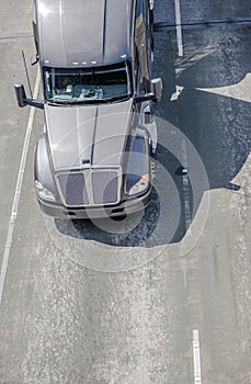 Big rig gray powerful long haul semi truck running on the highway for cargo delivery