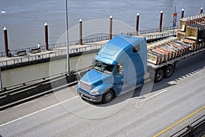 Big rig semi truck with flat bed semi trailer transporting commercial cargo on elevated road