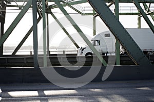Big rig long haul semi truck running on the bridge in sunshine