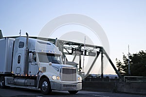 Big rig powerful semi truck running on evening twilight road
