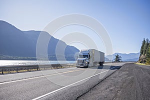 Big rig professional popular semi truck tor long haul freight transporting cargo in refrigerator semi trailer running on the road