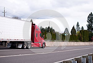 Big rig red semi truck tractor carry reefer semi trailer on the