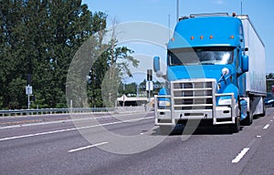 Big rig semi truck in blue color with long trailer and grille pr