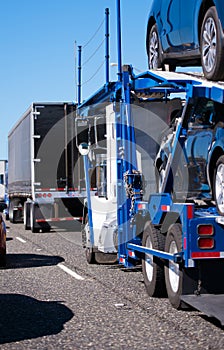 Big rig semi truck with car hauler trailer transporting cars on