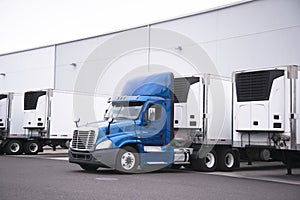 Big rig day cab semi truck and reefer trailers with refrigerator photo