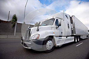 Big rig semi truck with reefer unit on refrigerator trailer running on the highway