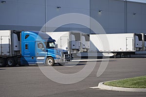 Big rig semi truck with refrigerated semi trailer standing for l