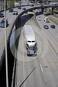 Big rig semi truck with semi trailer driving on the overpass road with heavy traffic