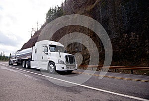 Big rig semi truck tractor transporting tank semi trailer on win